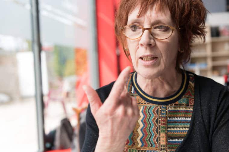Isabelle, près d'une fenêtre, en pleine discussion.