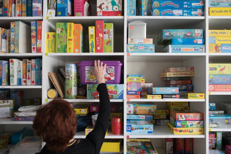 Isabelle se saisit d'une boîte parmi les jeux rangés dans la ludothèque