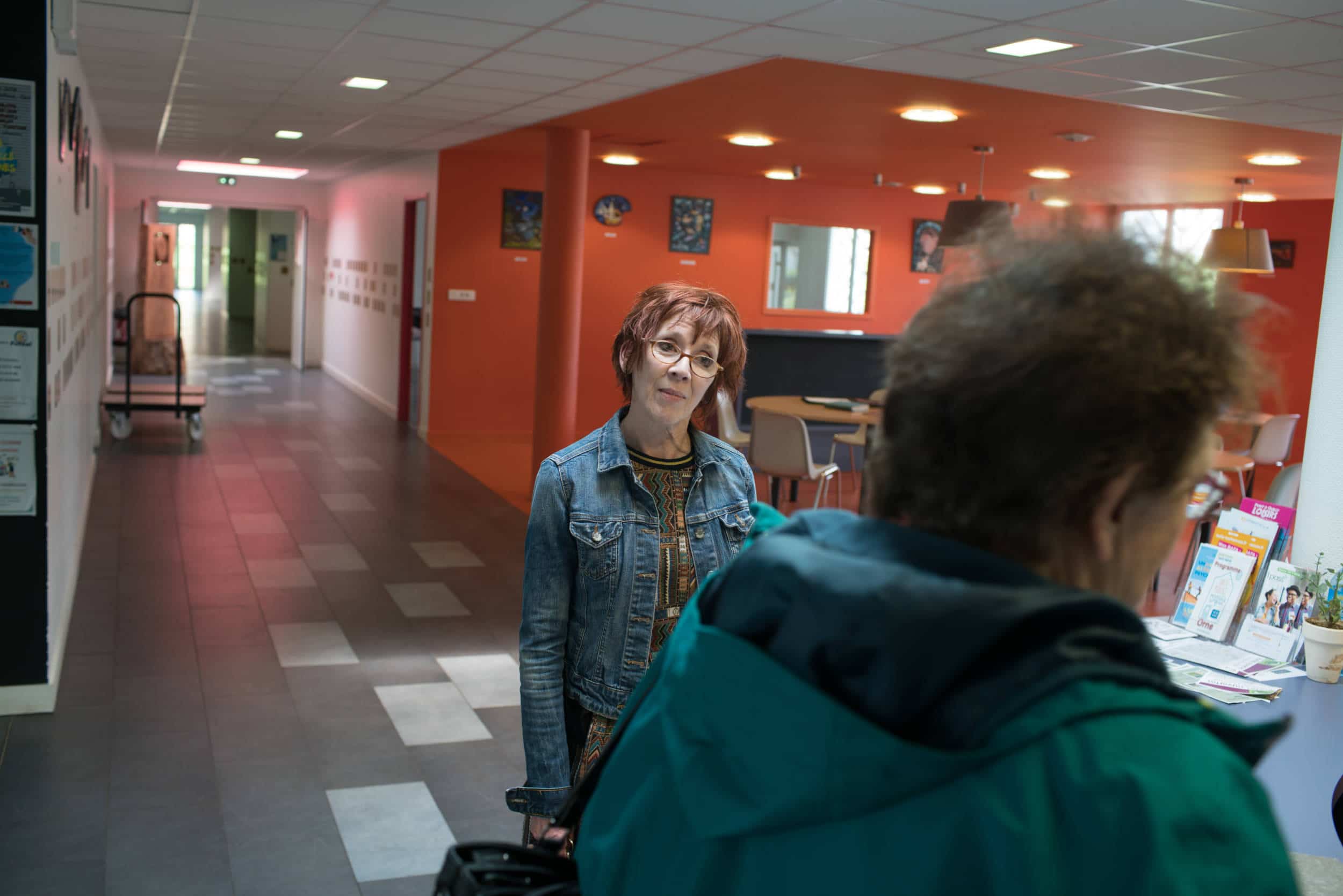 Isabelle se tient dans l'espace d'accueil de la maison d'activités