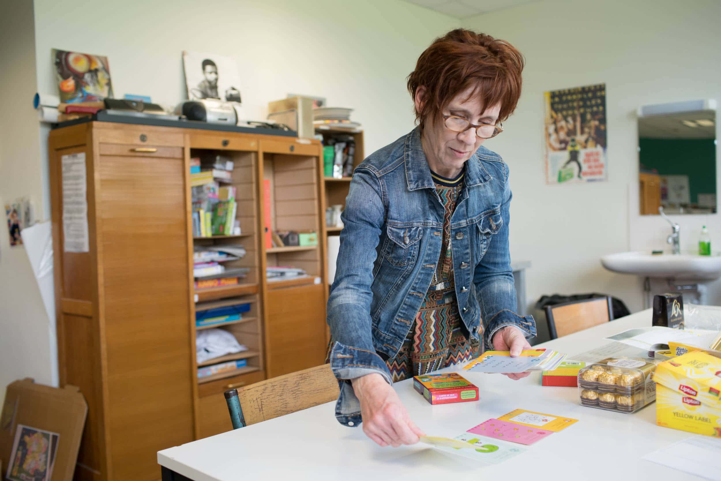 Isabelle dispose des cartes de jeux et d'apprentissage sur un bureau