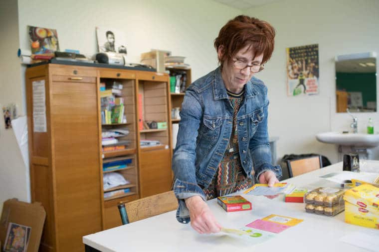 Isabelle dispose des cartes de jeux et d'apprentissage sur un bureau