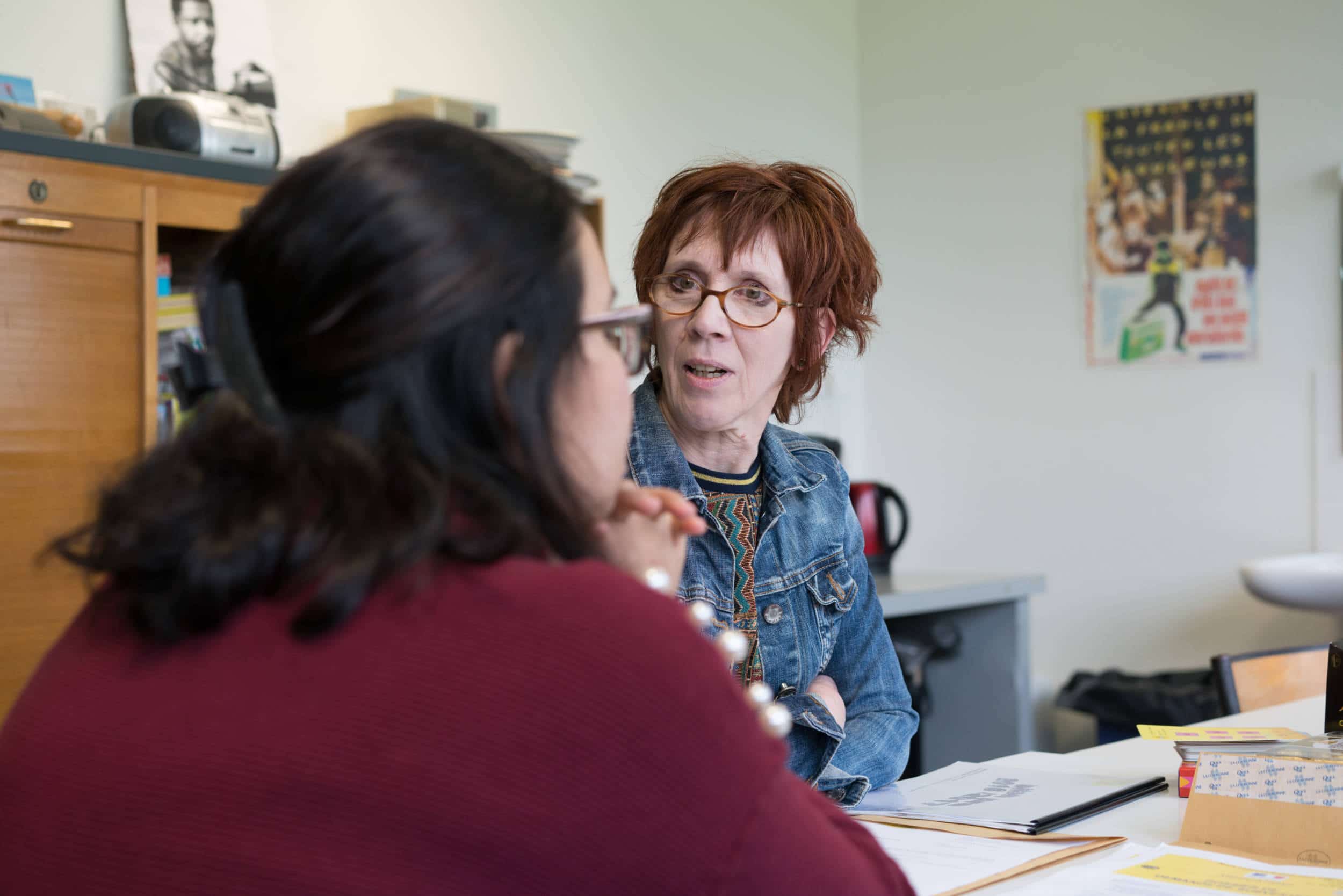 Isabelle converse avec une collègue autour d'une table