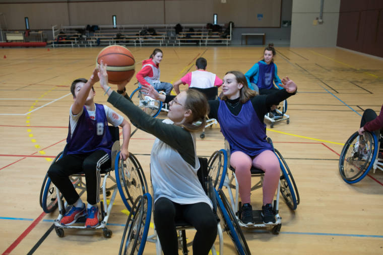 Deux équipes s'affrontent au basket en fauteuil roulant.