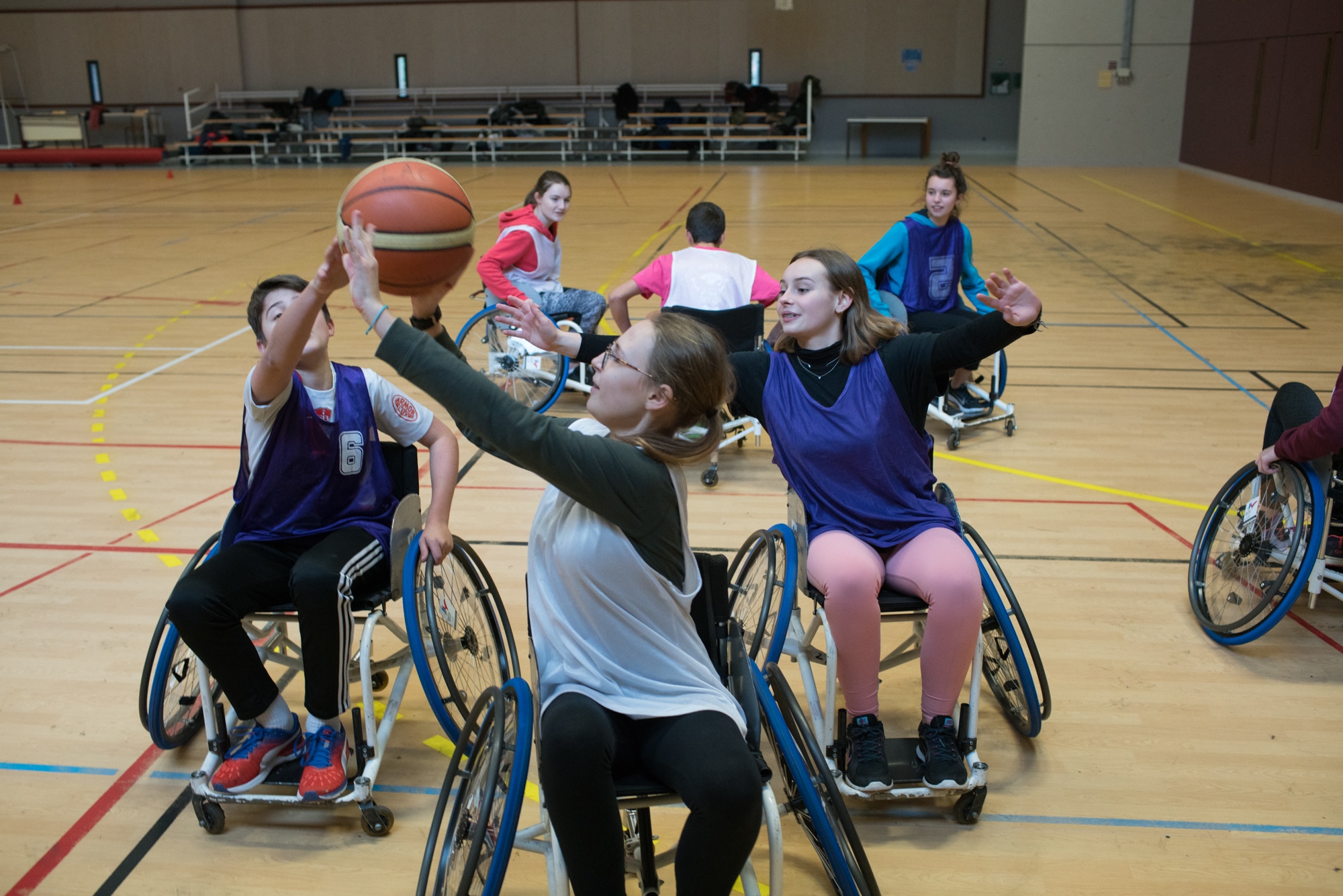 Deux équipes s'affrontent au basket en fauteuil roulant.