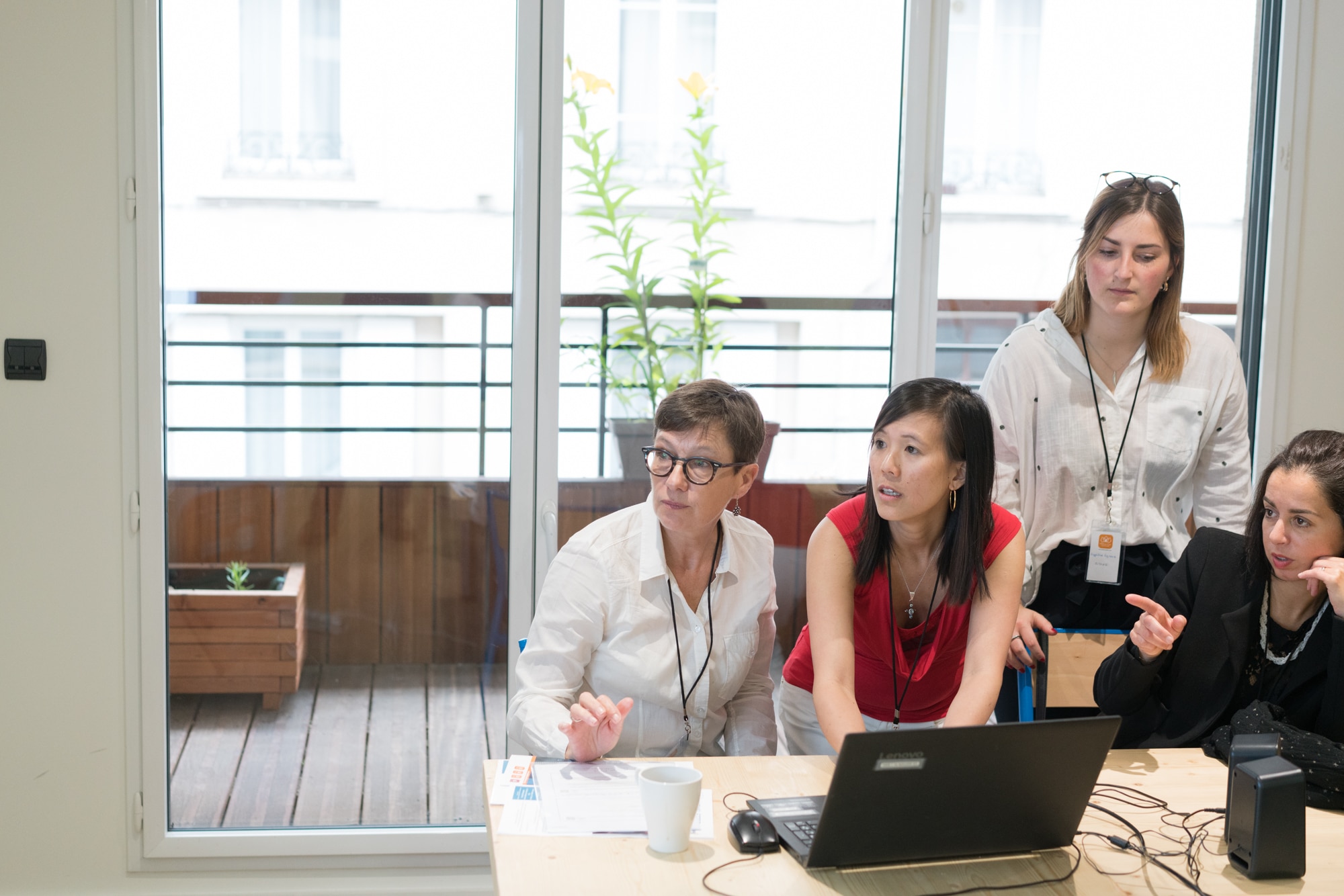 Mathilde est assise à côté de trois personnes derrière son ordinateur. Les regards sont dirigés vers l'écran de projection.