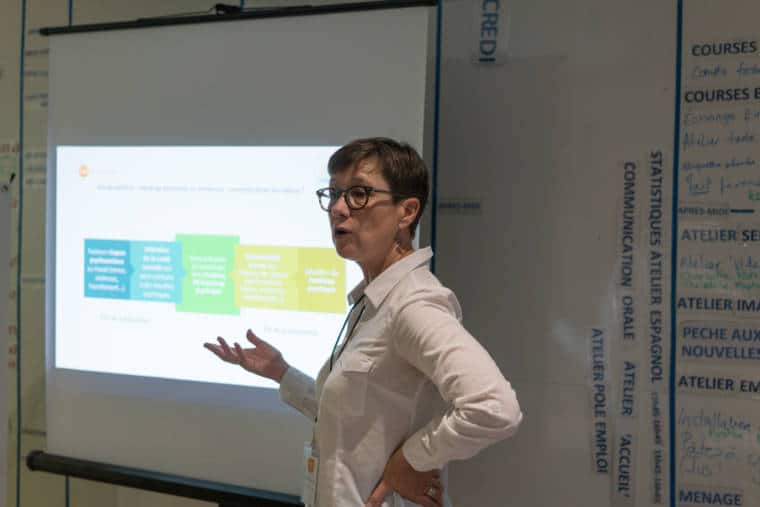 Mathilde s'adresse à son public, devant l'écran de projection.